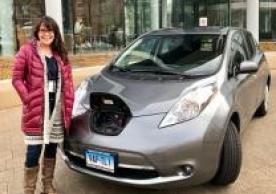 kim standing next to her nissan leaf