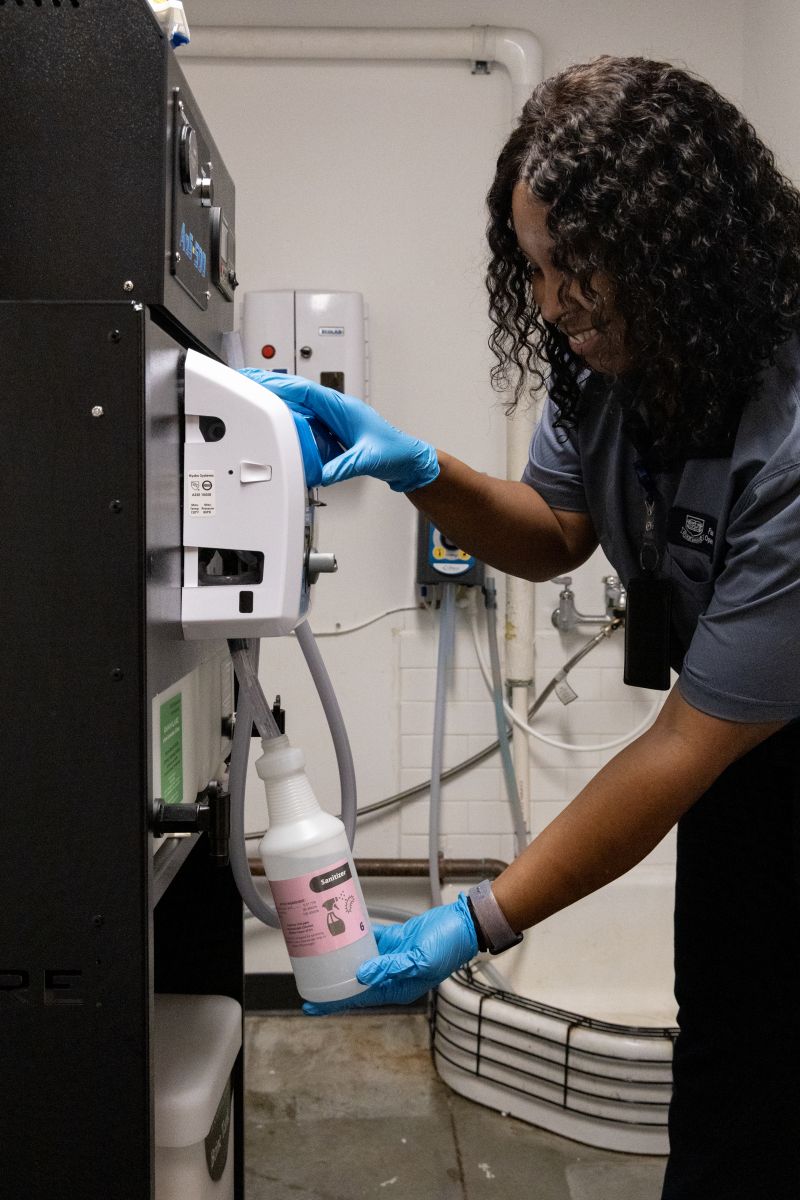 Yale custodial worker filling up a spray bottle with green cleaning solution