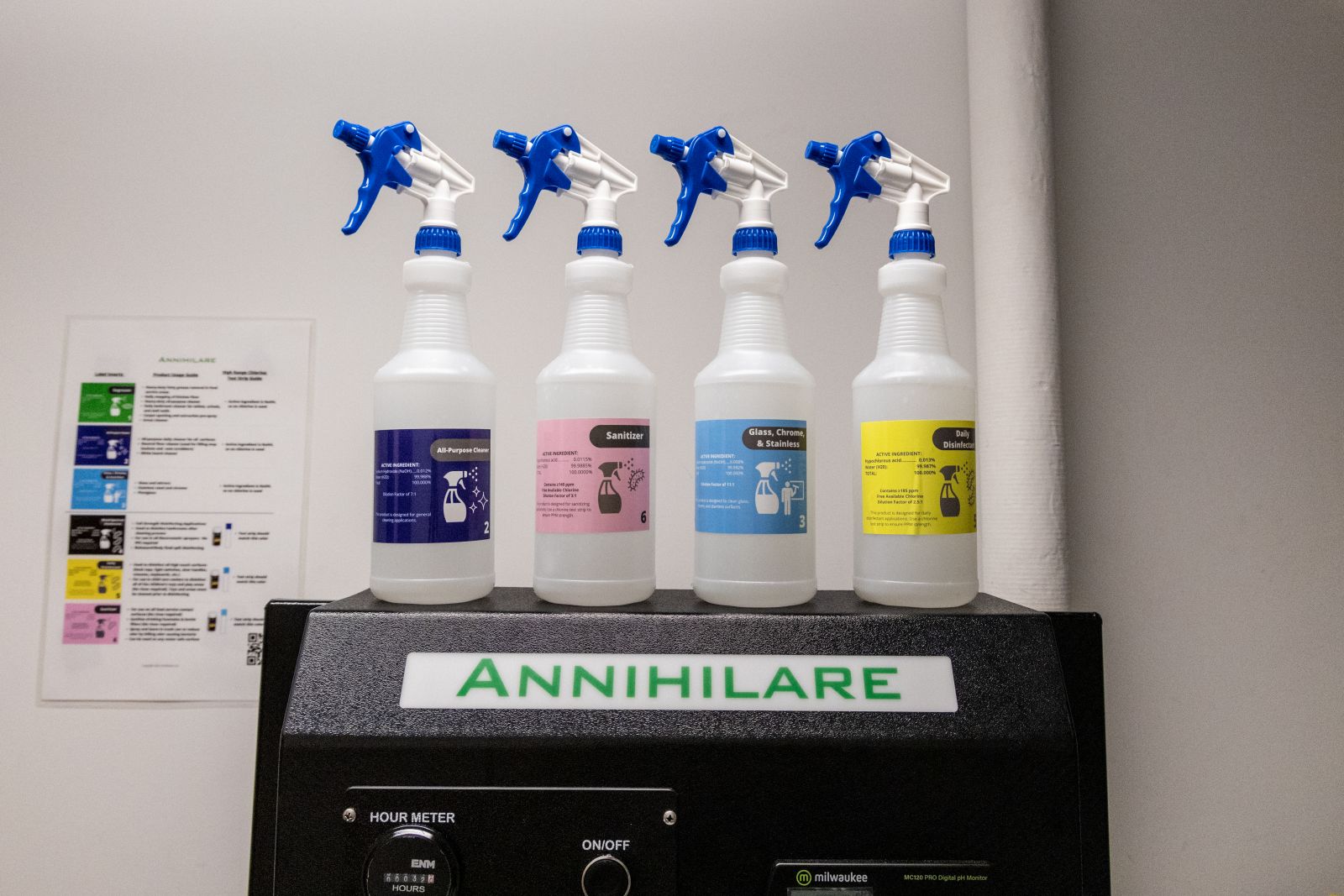 Four spray bottles on top of the Annihilare green cleaning machine