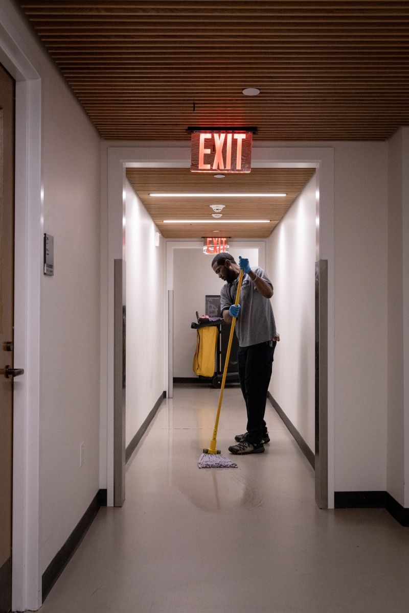 Yale custodian mopping a hallway with green cleaner