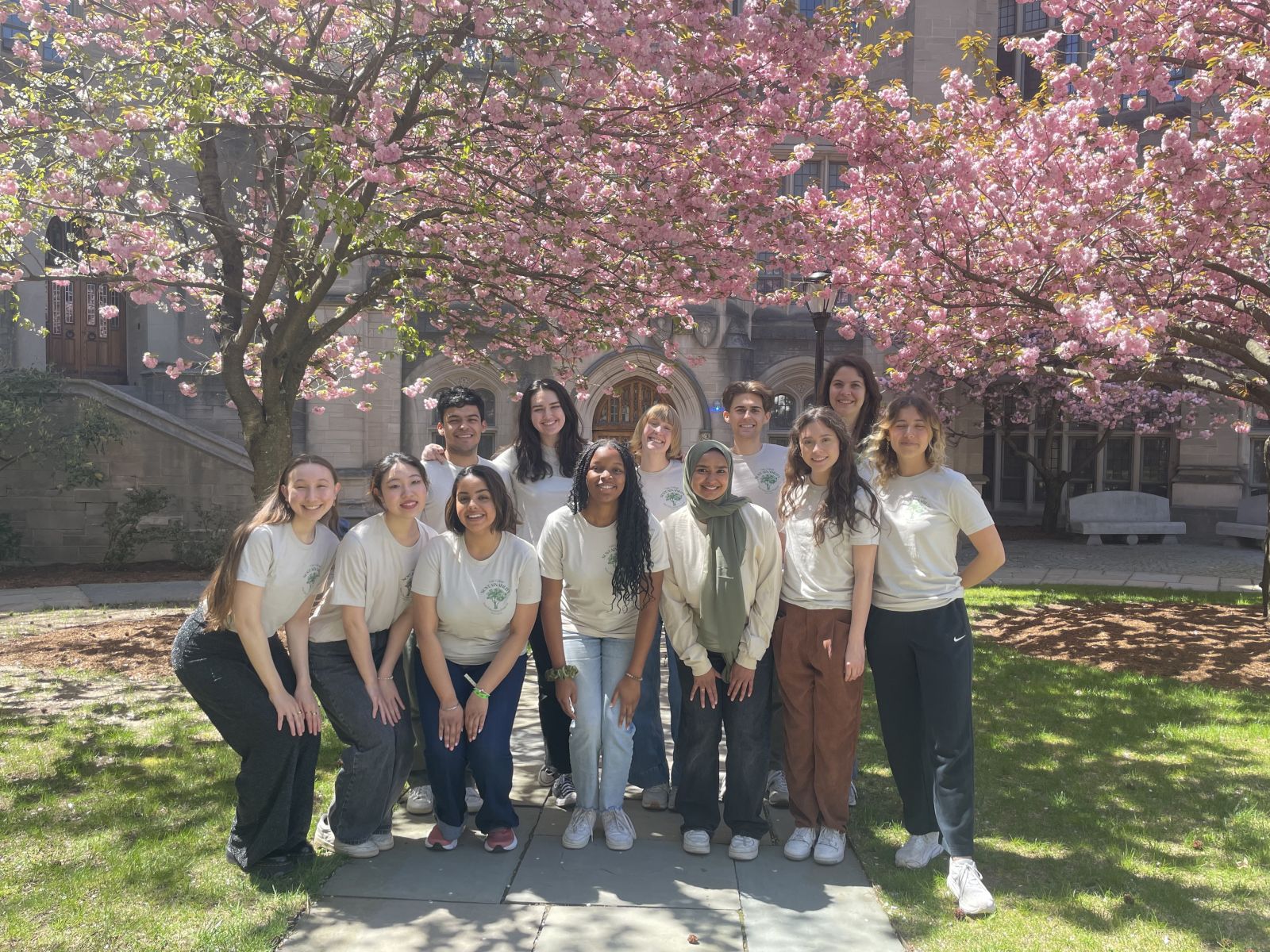 Students members of the Sustainability Peer Educator Program photographed under a flowering tree
