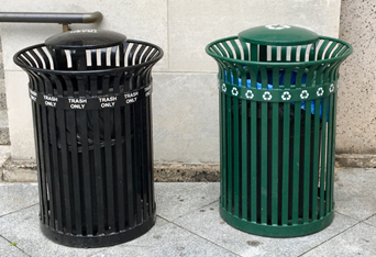  the bin on the left is black and labeled &quot;trash only&quot;, the bin on the right is green and labeled with the recycling symbol.