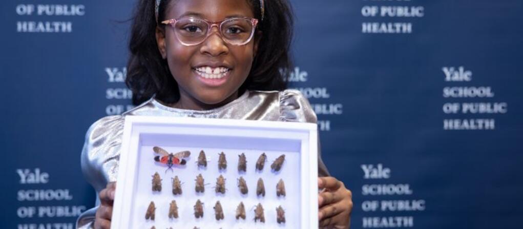 A photo of 9-year-old Bobbi Wilson holding a case containing her spotted lanternfly collection