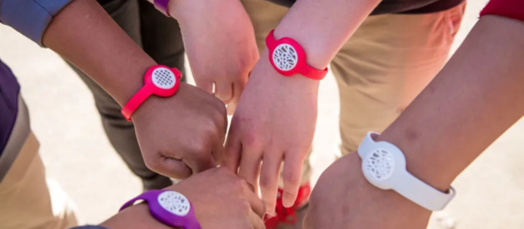 Hands together wearing Yale-designed fresh air wristbands