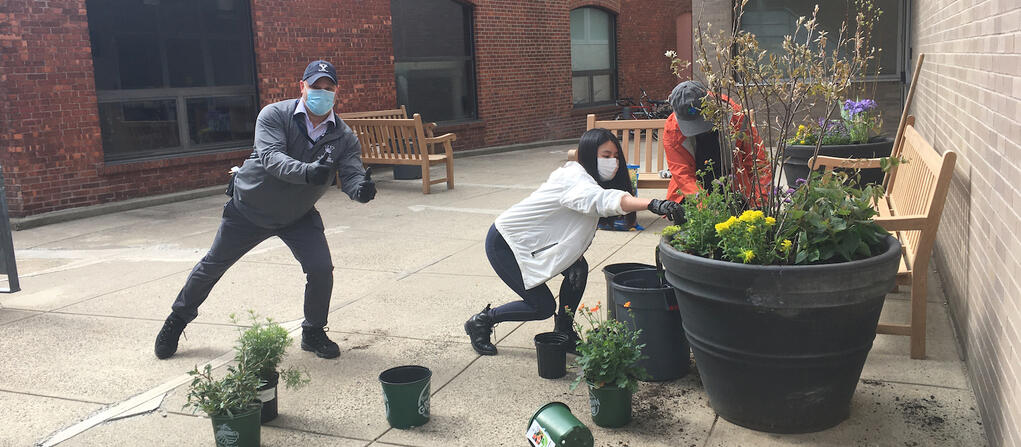 student moving a large planter