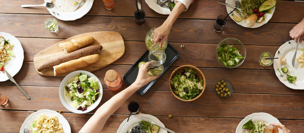 food on a thanksgiving table with people reaching for it