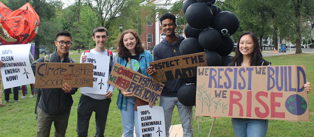 A photo of Yale students holding signs and demonstrating for climate action on the New Haven Green