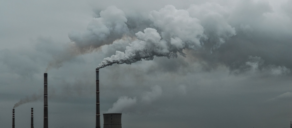 A photo of smokestacks with a gray sky in the background