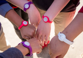 Hands together wearing Yale-designed fresh air wristbands