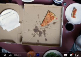 Overhead photo of a greasy pizza box and pizza slice