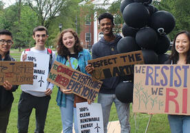 A photo of Yale students holding signs and demonstrating for climate action on the New Haven Green